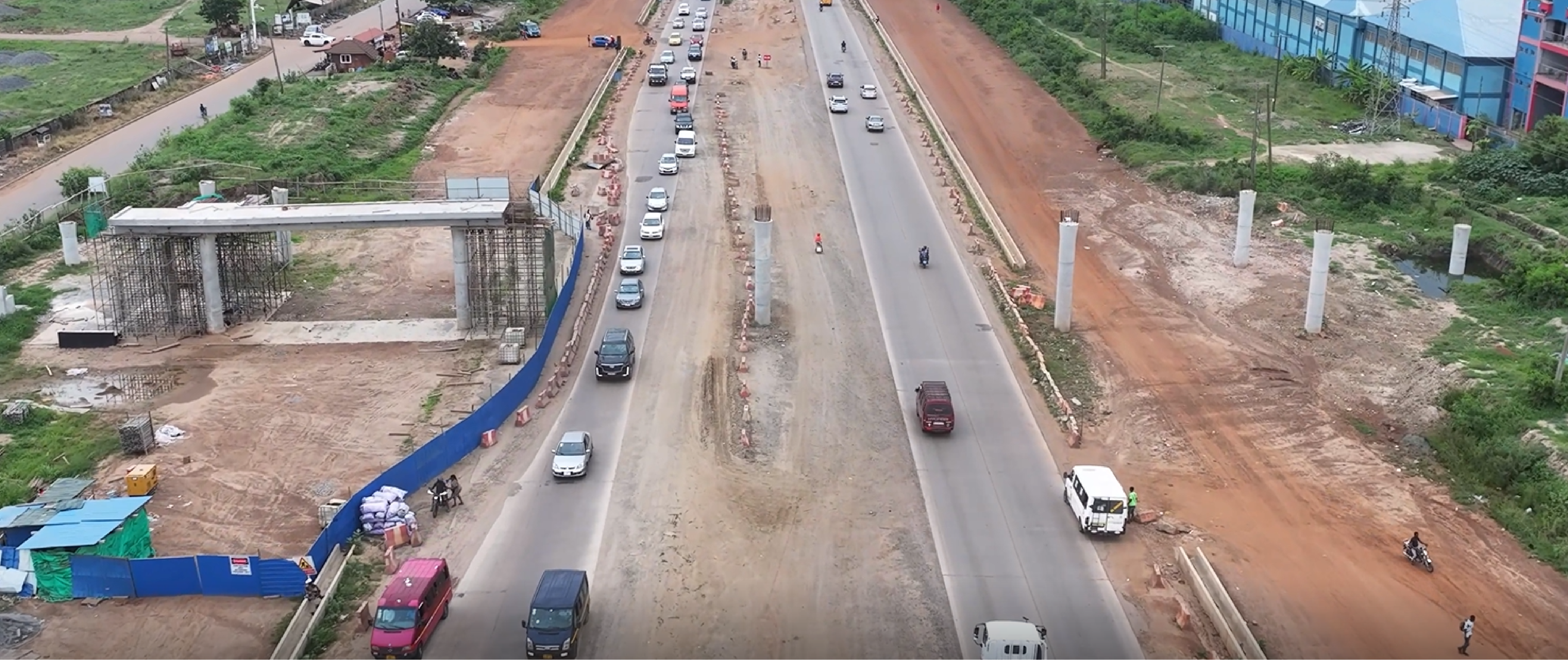 Aerial view of the corridor with new bridge piers and columns rising alongside traffic lanes